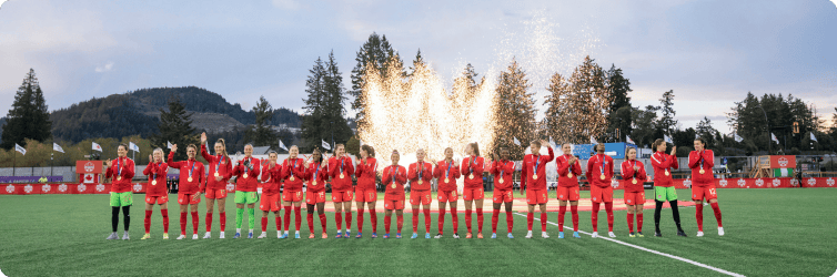 Team Canada Soccer players lined up with fireworks in the background