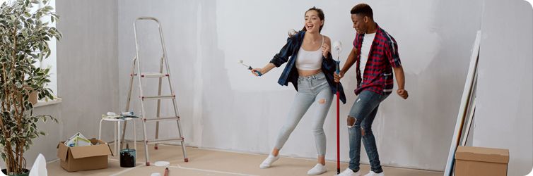 two friends having fun renovating their home and dancing